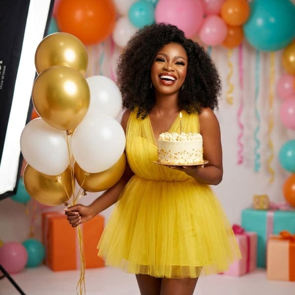 Birthday shoot with balloons and cake in a bright yellow tulle dress